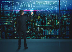 Businessman drawing business statistics on glass wall